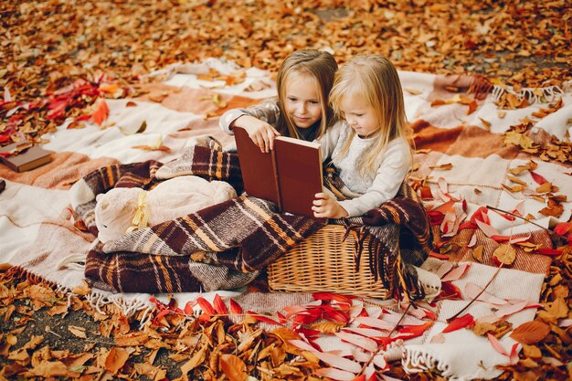 Niñas lindas en un parque de otoño