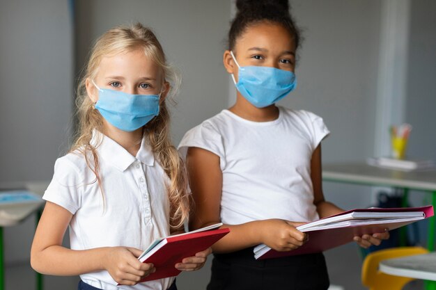 Niñas con máscaras médicas en clase.