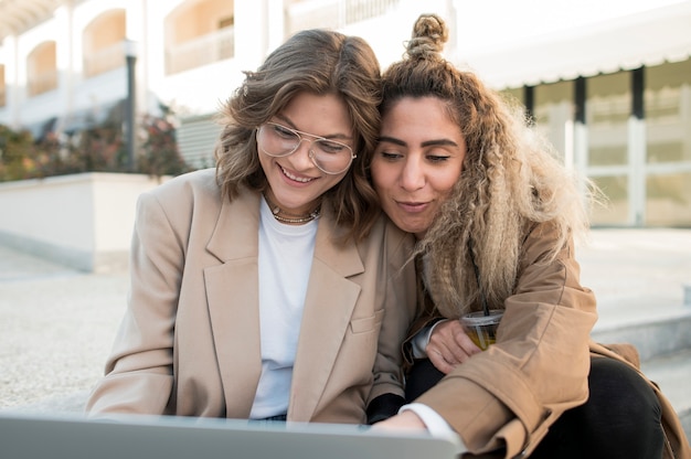 Foto gratuita niñas mirando algo en la computadora portátil