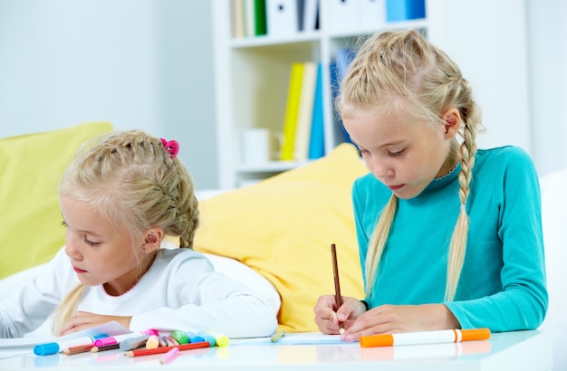 Foto gratuita niñas con muchos lápices de colores en la mesa