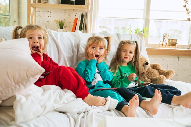 Niñas en pijama suave y cálido jugando en casa