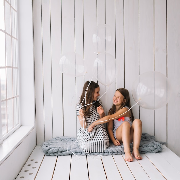 Foto gratuita niñas riendo jugando con globos