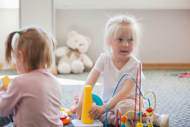 Las niñas en la sala de juegos con juguetes