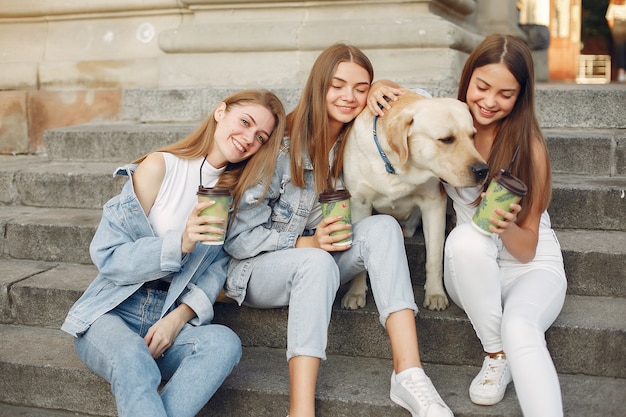 Niñas sentadas en una escalera con lindo perro