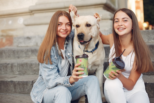 Niñas sentadas en una escalera con lindo perro