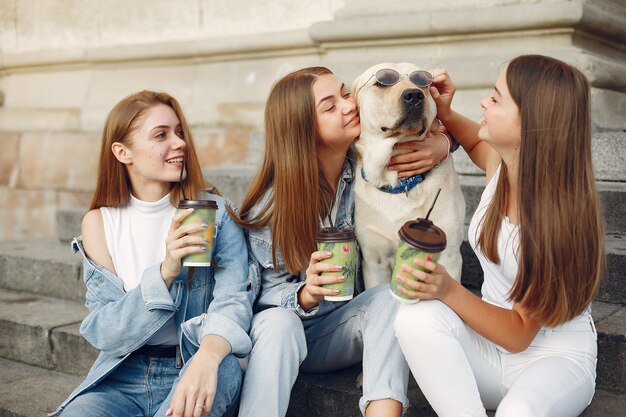 Niñas sentadas en una escalera con lindo perro