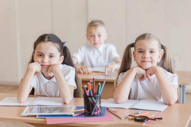 Niñas sentadas en el escritorio en el aula