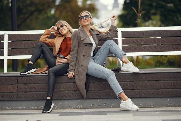 Las niñas sentadas en una primavera sity y sostienen el café en la mano