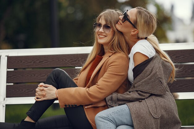 Las niñas sentadas en una primavera sity y sostienen el café en la mano