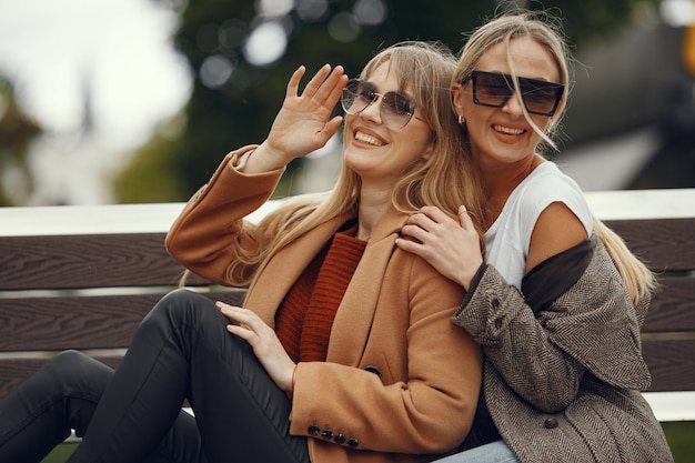 Las niñas sentadas en una primavera sity y sostienen el café en la mano