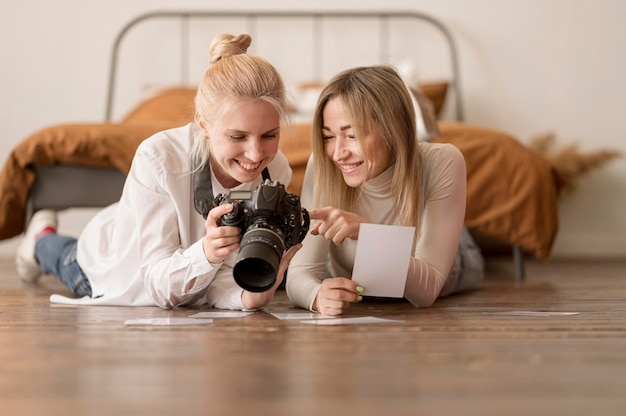 Niñas sentadas en el suelo y mirando fotos