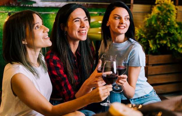 Niñas sonriendo al vino tostado en fiesta