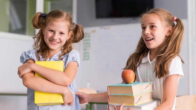 Niñas sonriendo mientras sostienen sus libros