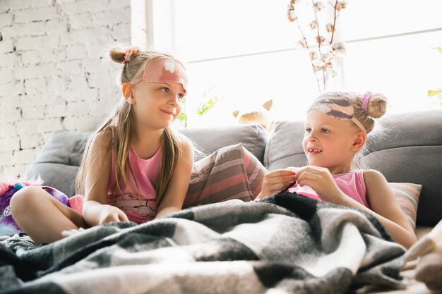 Niñas tranquilas que se despiertan en una habitación con lindos pijamas, estilo hogareño y comodidad