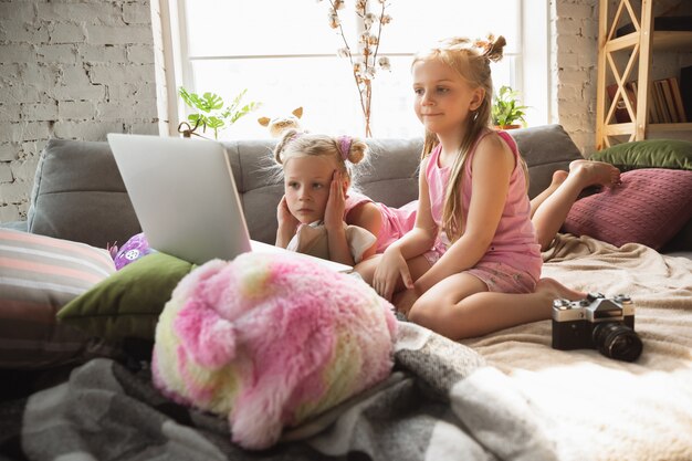 Niñas tranquilas que se despiertan en una habitación con lindos pijamas, estilo hogareño y comodidad