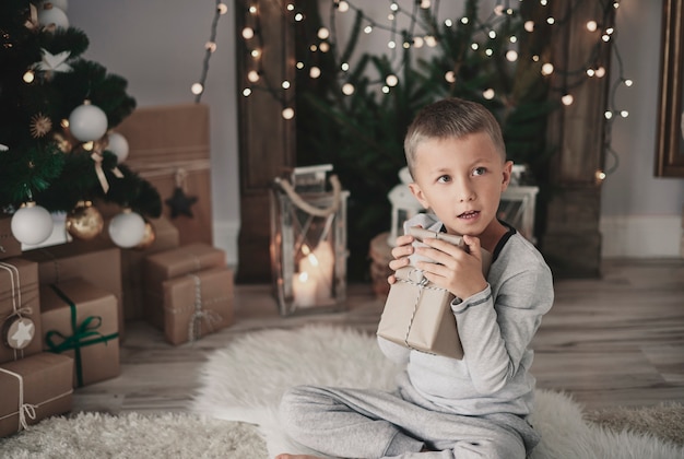 Niño abrazando un regalo de Navidad