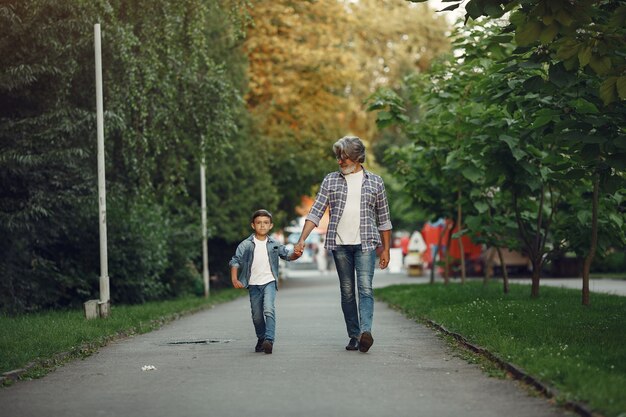 Niño y abuelo están caminando en el parque. Anciano jugando con su nieto.