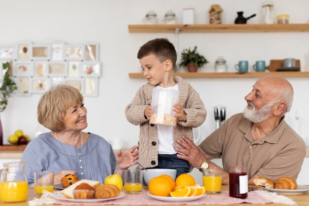 Niño y abuelos sonrientes de tiro medio