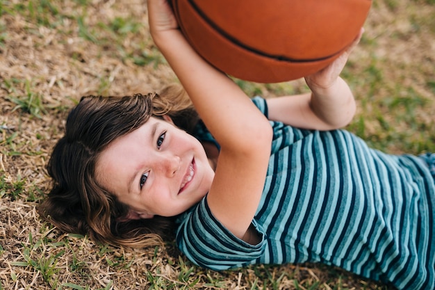 Niño acostado en el césped y sosteniendo la bola