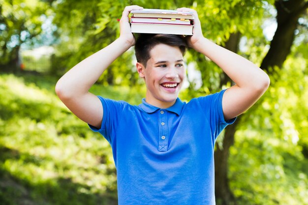 Niño adolescente sonriente con libros