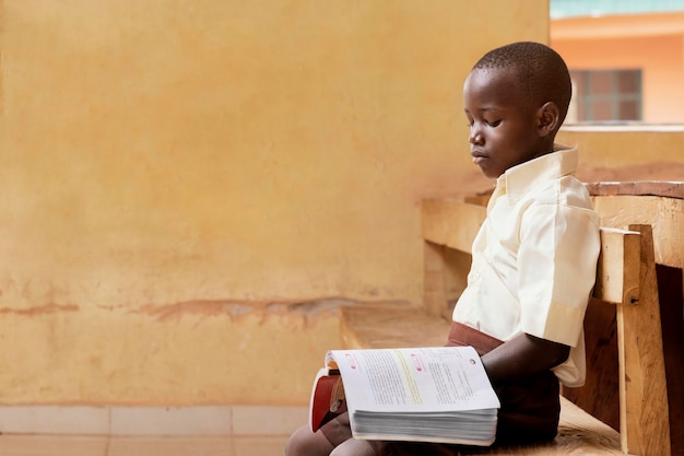 Niño africano apoyado en clase