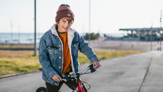 Niño al aire libre en la ciudad con una bicicleta.