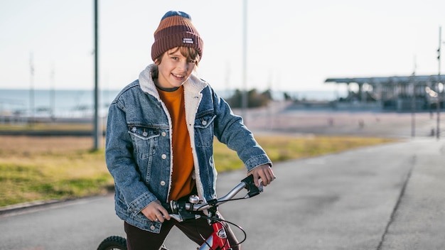 Niño al aire libre en la ciudad con una bicicleta.