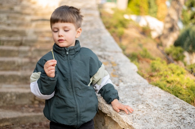 Foto gratuita niño al aire libre con diente de león