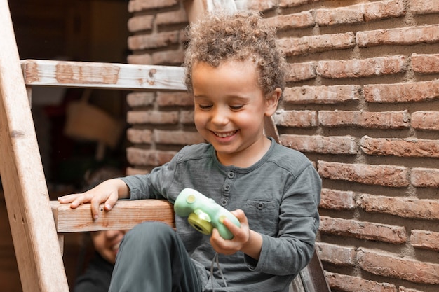 Niño al aire libre con juguete de cámara