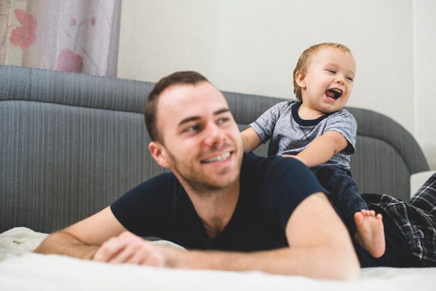 Niño alegre en la espalda de su padre