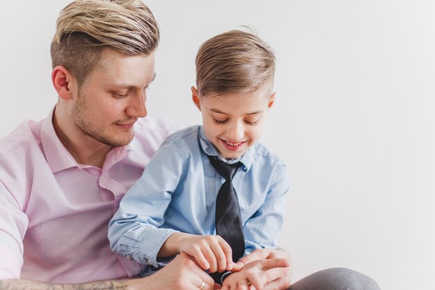 Niño alegre jugando con las manos de su padre