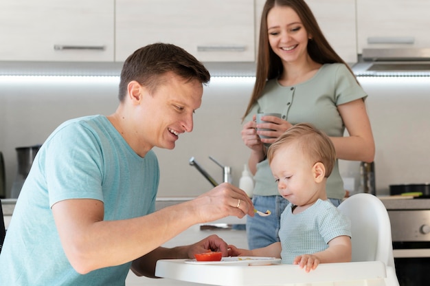 Foto gratuita niño de alimentación de padre de tiro medio