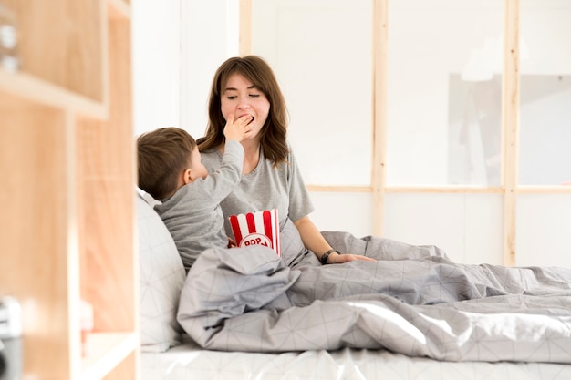 Niño alimentando a su madre con palomitas de maíz