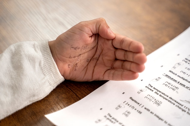 Foto gratuita niño de alto ángulo haciendo trampa en el examen escolar