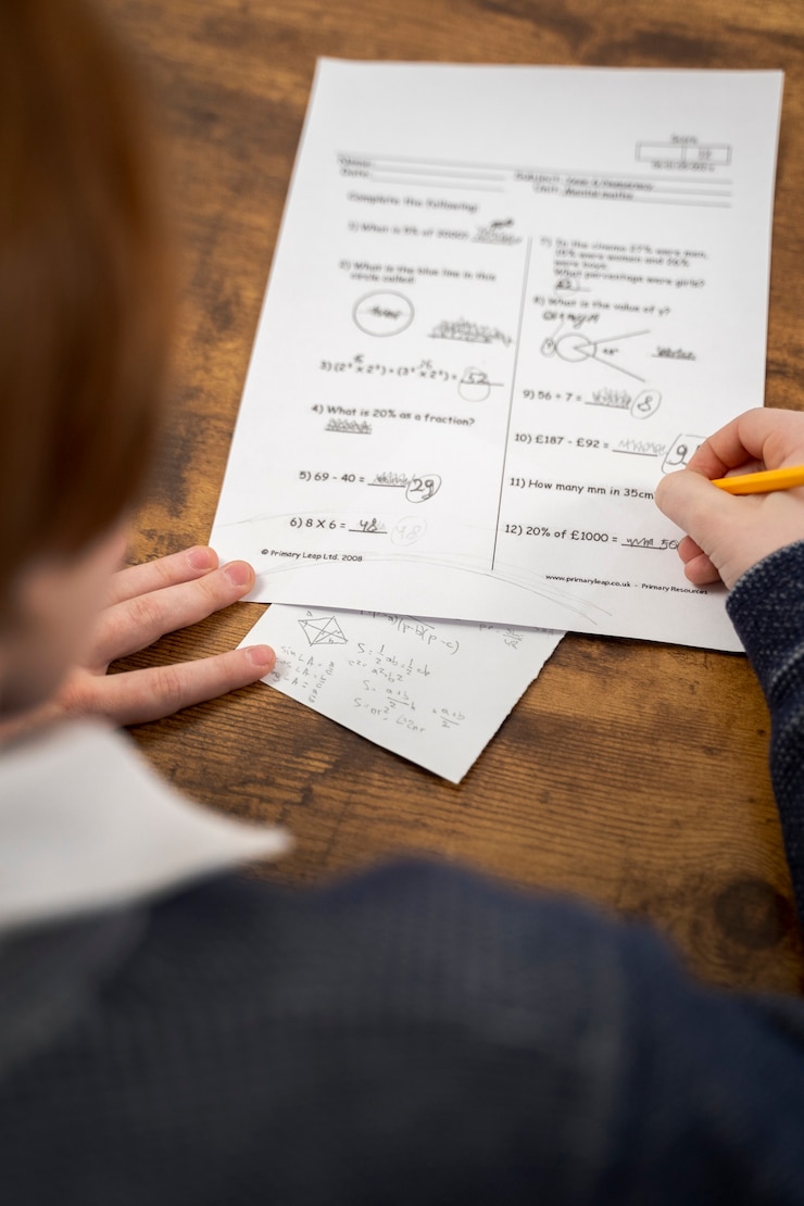 Foto gratuito niño de alto ángulo haciendo trampa en el examen de la escuela