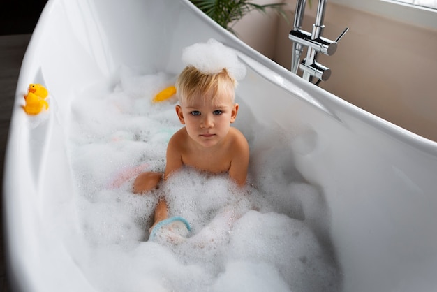 Niño de alto ángulo jugando en la bañera