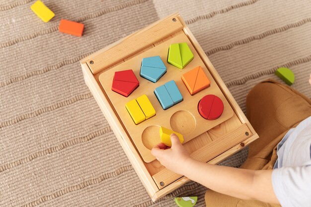 Niño de alto ángulo jugando con juguete de madera