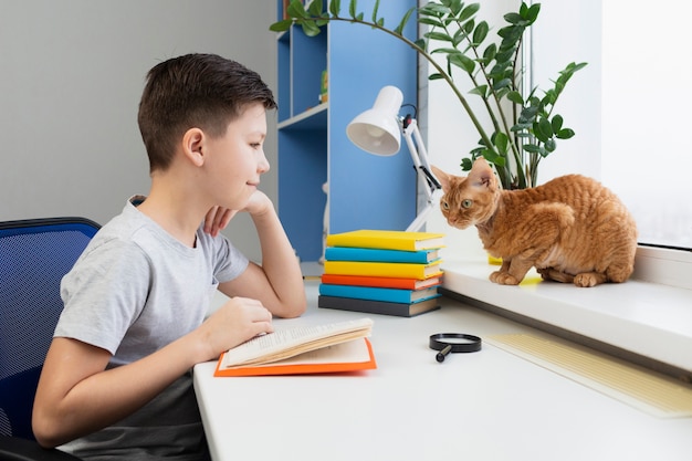 Niño de alto ángulo con lectura de gato