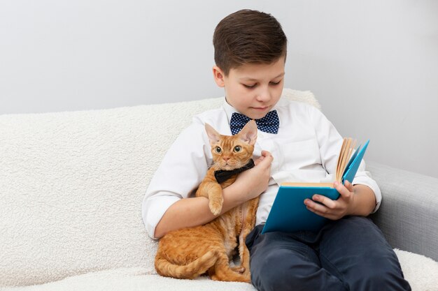 Niño de alto ángulo con lectura de gato