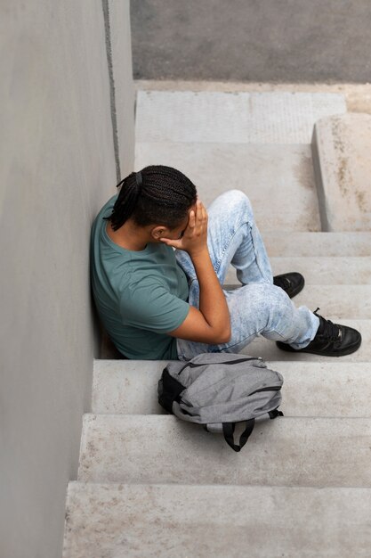 Niño de alto ángulo llorando en las escaleras