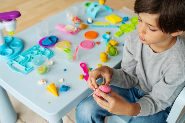 Niño de alto ángulo con plastilina