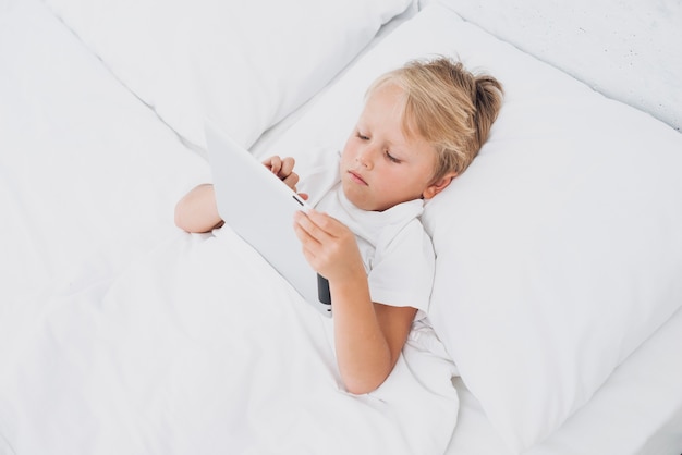 Niño de alto ángulo viendo algo en una tableta