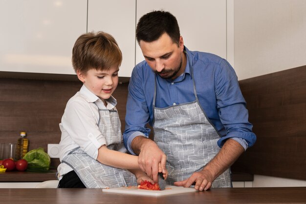 Niño de ángulo bajo en la cocina con padre