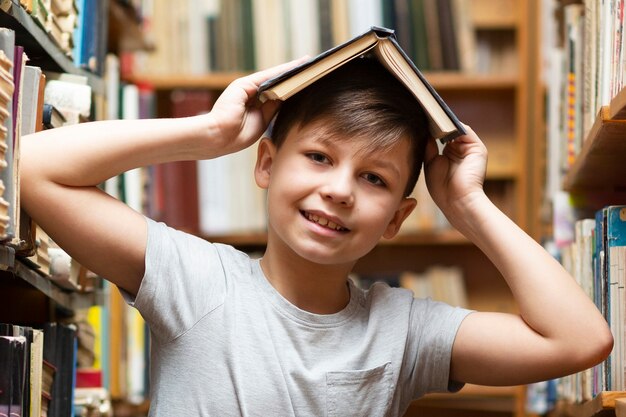 Niño de ángulo bajo con libro en cabeza