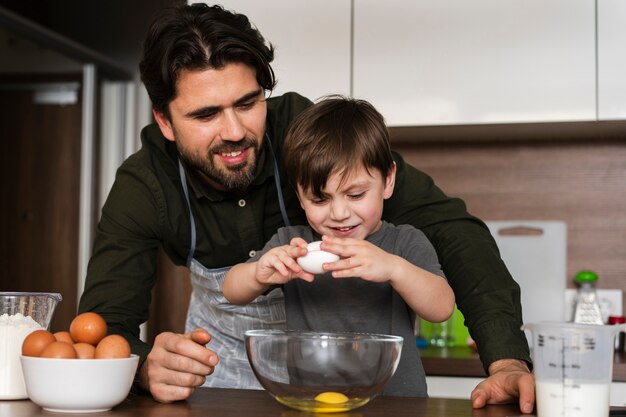 Niño de ángulo bajo que quiebra huevos