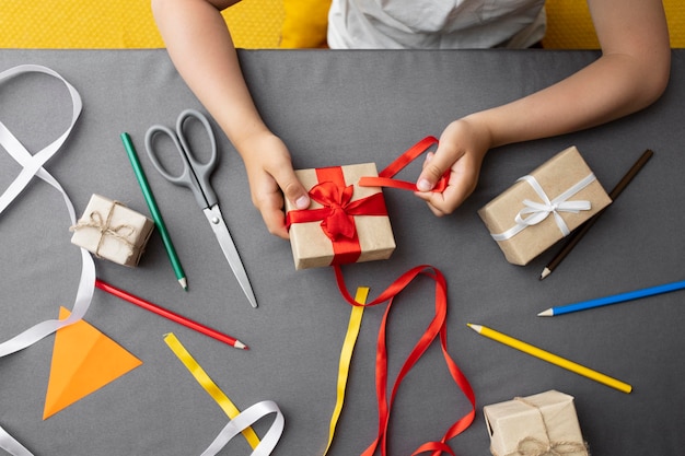 Niño aprendiendo a hacer un regalo