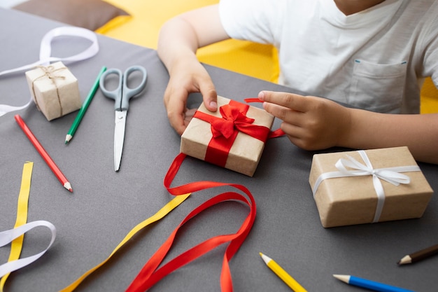 Niño aprendiendo a hacer un regalo