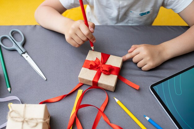 Niño aprendiendo a hacer un regalo