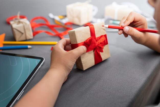 Niño aprendiendo a hacer un regalo