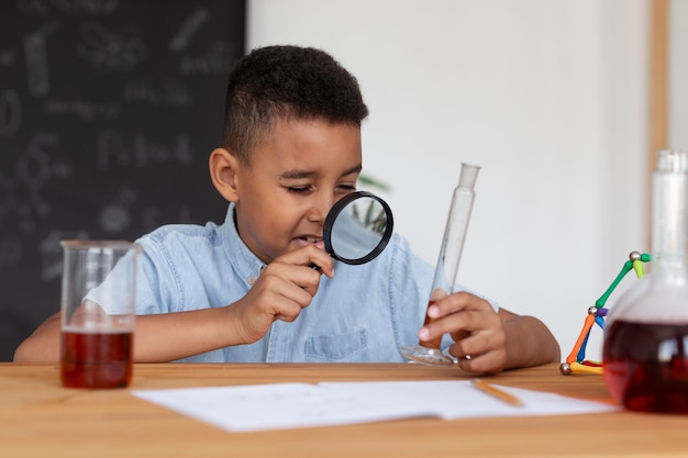 Niño aprendiendo más sobre química en clase.